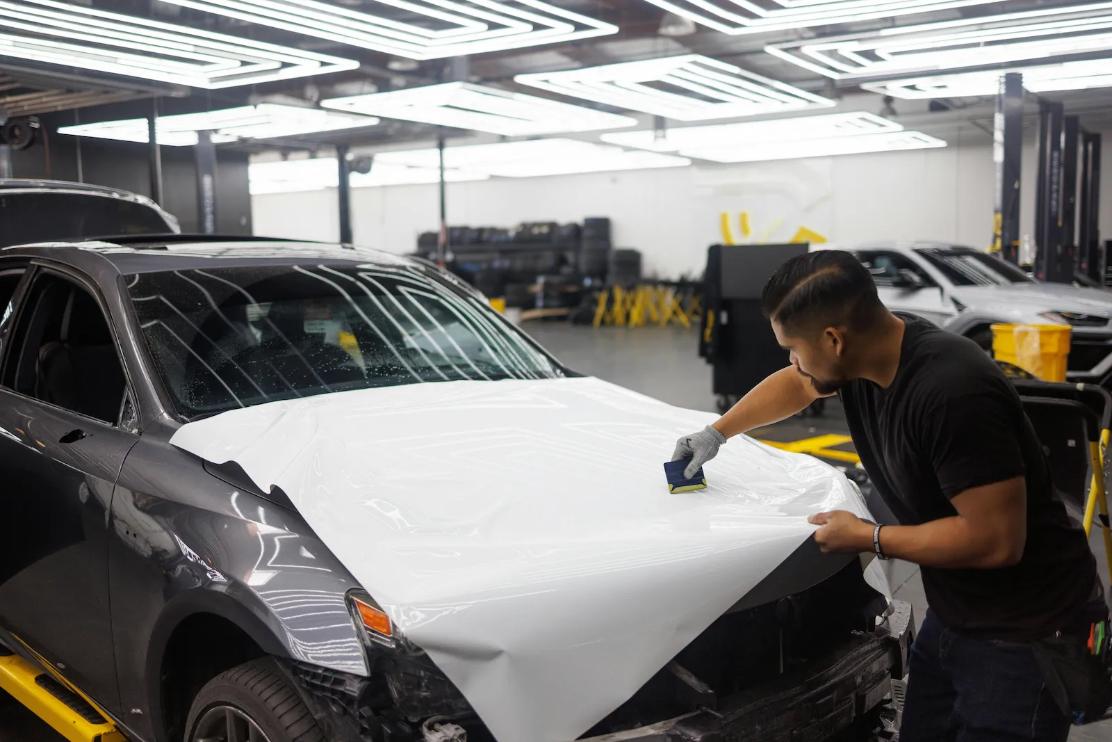 Automotive technician performing high-precision paint enhancement